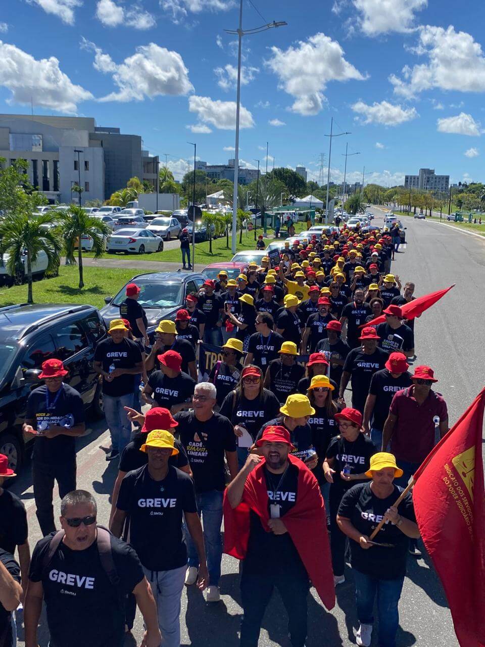 Servidores do Judiciário baiano em passeata de greve, com camisas do SINTAJ e bandeiras do sindicato